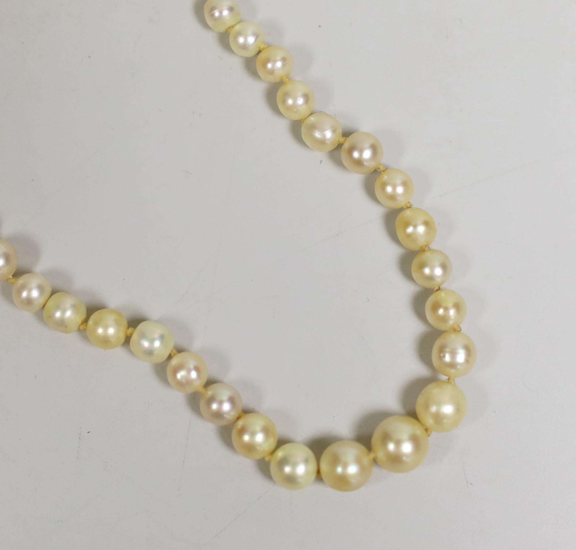 A single strand graduated natural pearl necklace (needs re-stringing), with accompanying Gem & Pearl Testing Laboratory of Bahrain report.